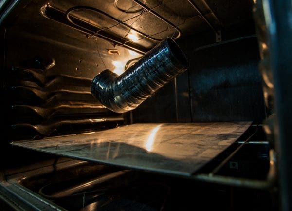 The hose goes through two curing processes. The first cure is to vulcanize the silicone. By being heated in the oven for an hour at 225°F, the silicone will go from a soft malleable material to a solid, holding its shape enough that the mold and binding tape can be removed. The second cure is more of an aging process, where after 4 hours at 350°F the silicone will not degrade or discolor, even after repeated pulls on our dyno.