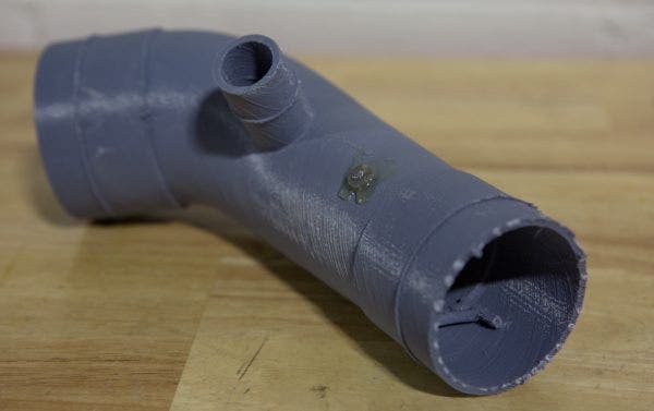 The process of creating a silicone hose starts with the mold. While this might look very similar to the 3D printed hose from above, but this mold is an adapted version of that design. Ye decreased the diameter for this version to compensate for the silicone that will be layered on top, and will cure at the correct dimensions. You might also notice a series of raised edges through out this print. These are cut lines. Once the silicone is cured on the mold, these raised edges will give Mike a template on where to cut excess material.