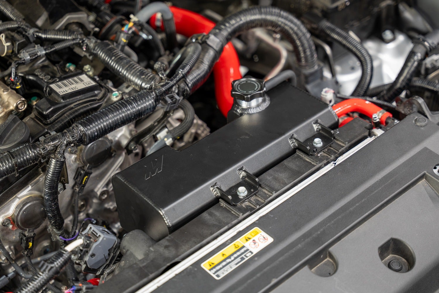 The Mishimoto Aluminum Expansion tank for the 2024+ Toyota Tacoma installed in the engine bay.